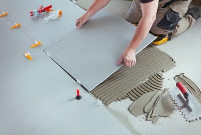 Professional tiler installing new tiles on the floor.